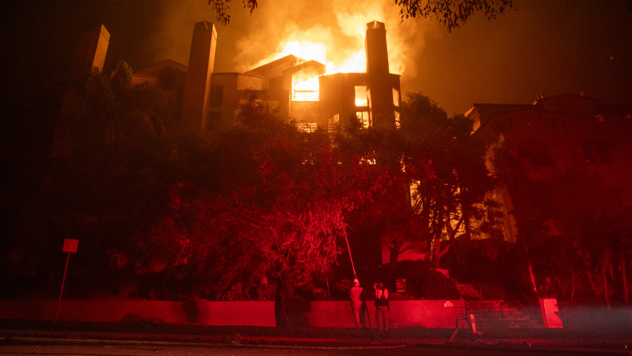 Flames from the Palisades Fire burn a residential building in Los Angeles on Thursday.